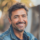 Homme souriant en extérieur, veste en jean.